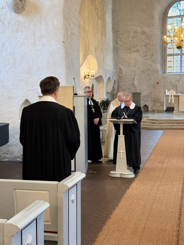 Vaimulik loeb pulbist, ees seisavad teised vaimulikud