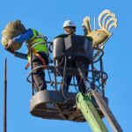 Töömehed tõstukiga tornikiivri tipus tornikukke ja kuke-muna alla võtmas
