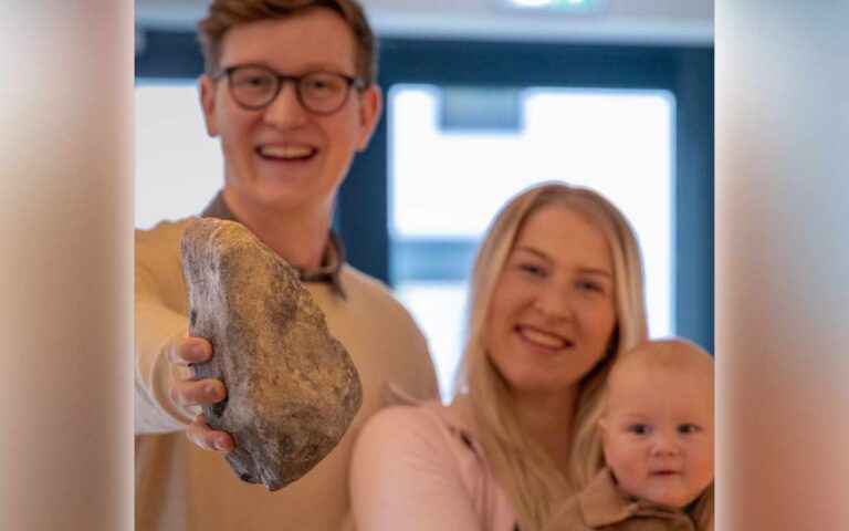 Mattias Haamer hoiab käes Põltsamaalt toodud kivi, taustal tema abikaasa ja laps